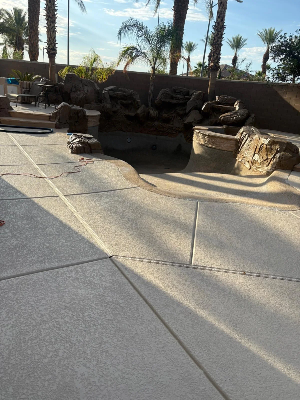 Concrete pool deck resurfacing around a rock waterfall pool in Las Vegas, NV